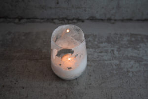 Salzkristall-Teelicht mit brennender Kerze darin.