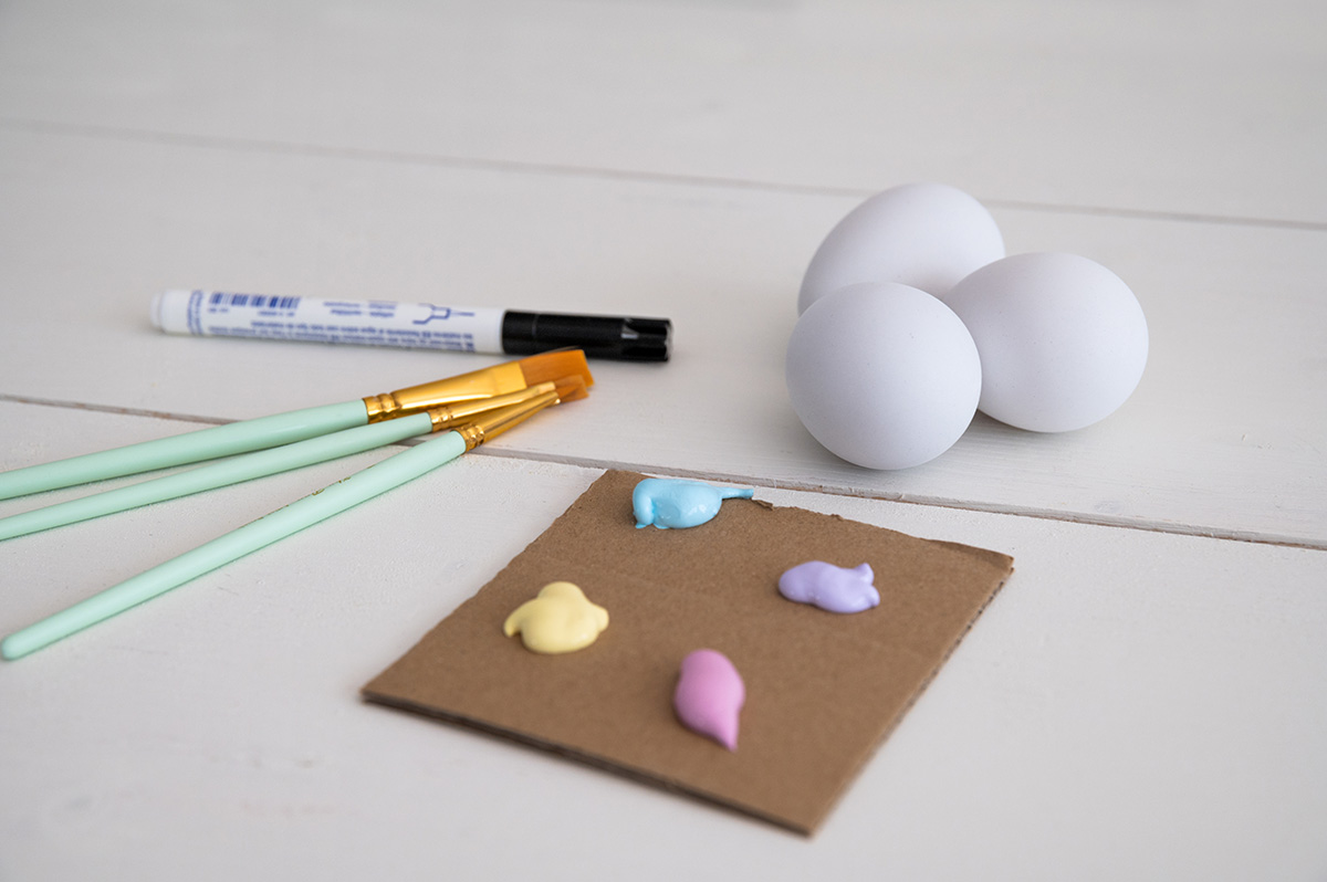 Alles was man für die Line Art Eier braucht: weiße Plastikeier, Acrylfarbe, Pinsel und schwarzen Filzstift.