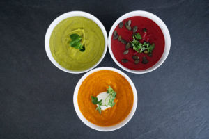 Vogelperspektive von drei Tellern mit verschiedenen Detox Suppen: Avocado-Erbsen-Suppe, Rote Bete SUppe und Karotten-Kurkuma Suppe.